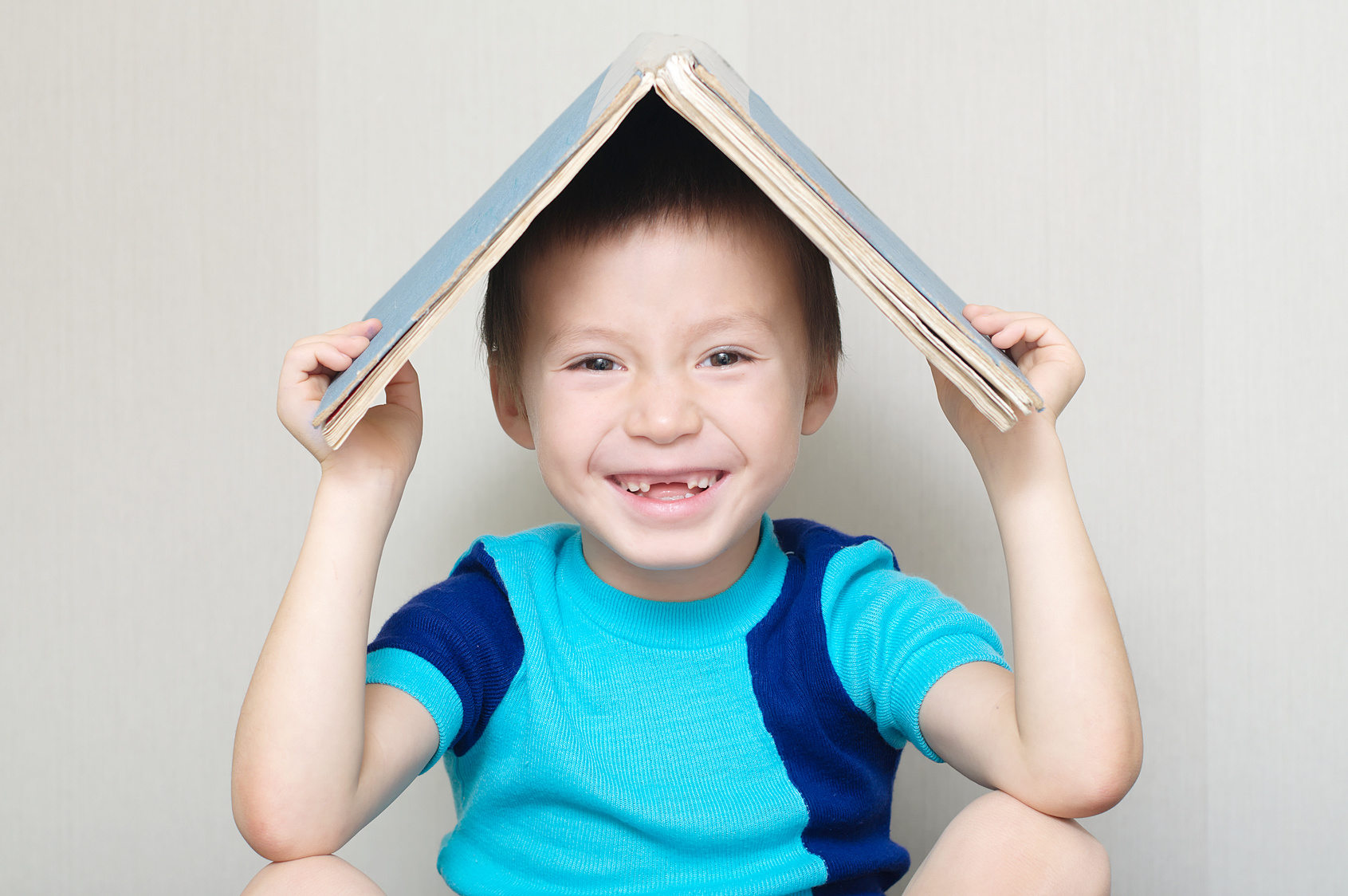 Un enfant avec un livre sur la tête